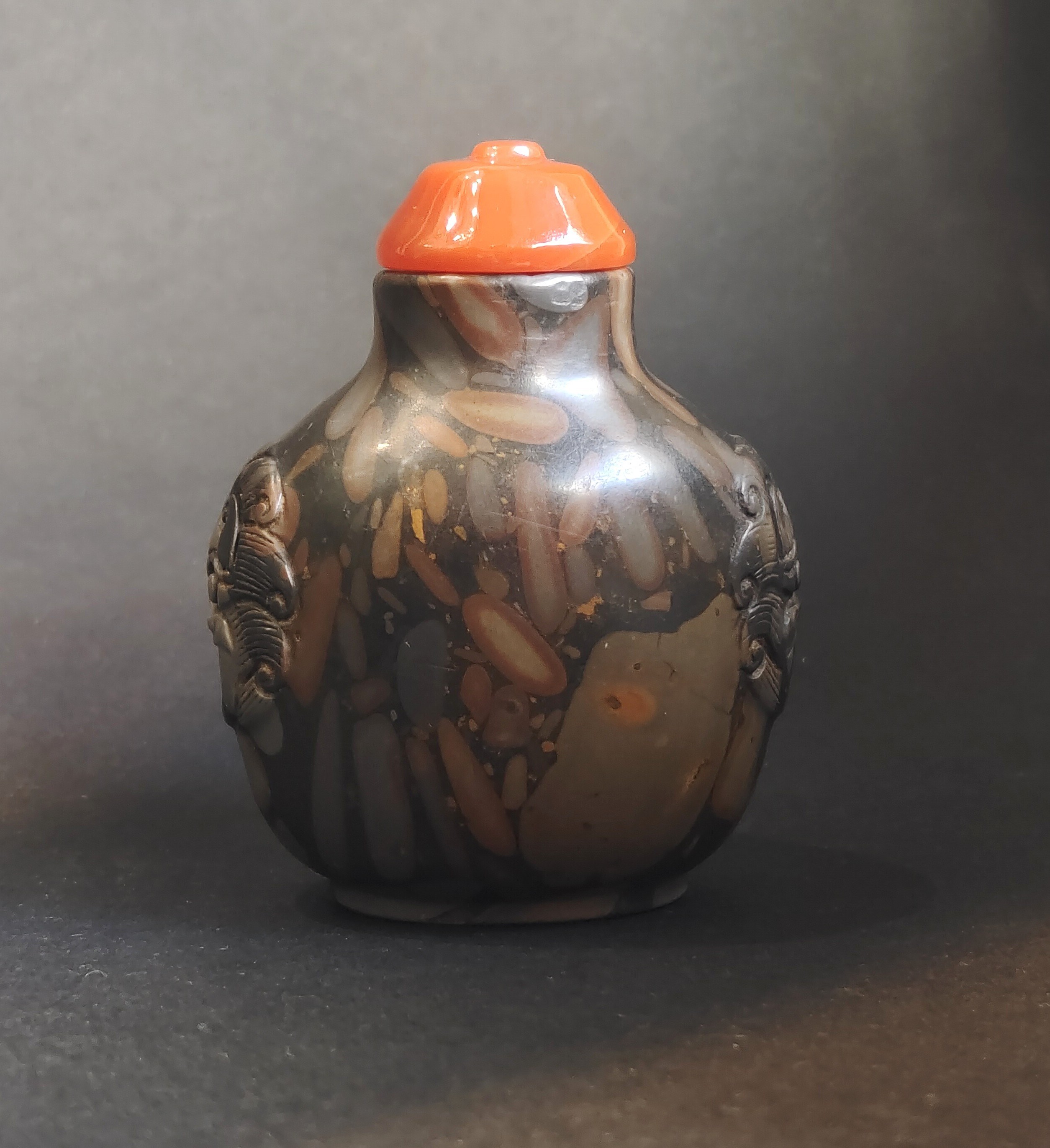 Snuff bottle in puddingstone  sculpté de masques sur les cotés
Chine 19th century 